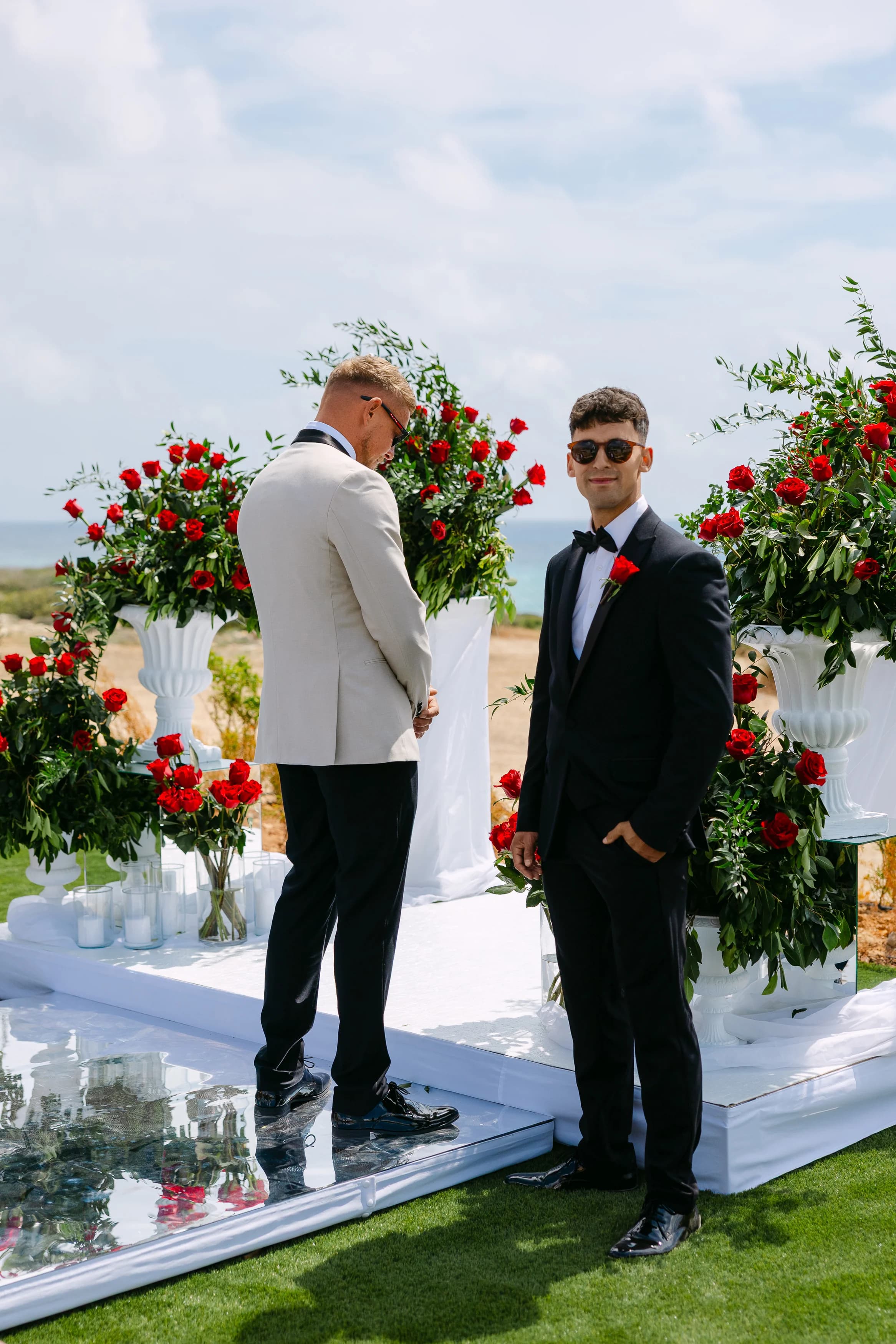 Groom waiting at the floral altar at Ozea with a witness beside him before the ceremony.