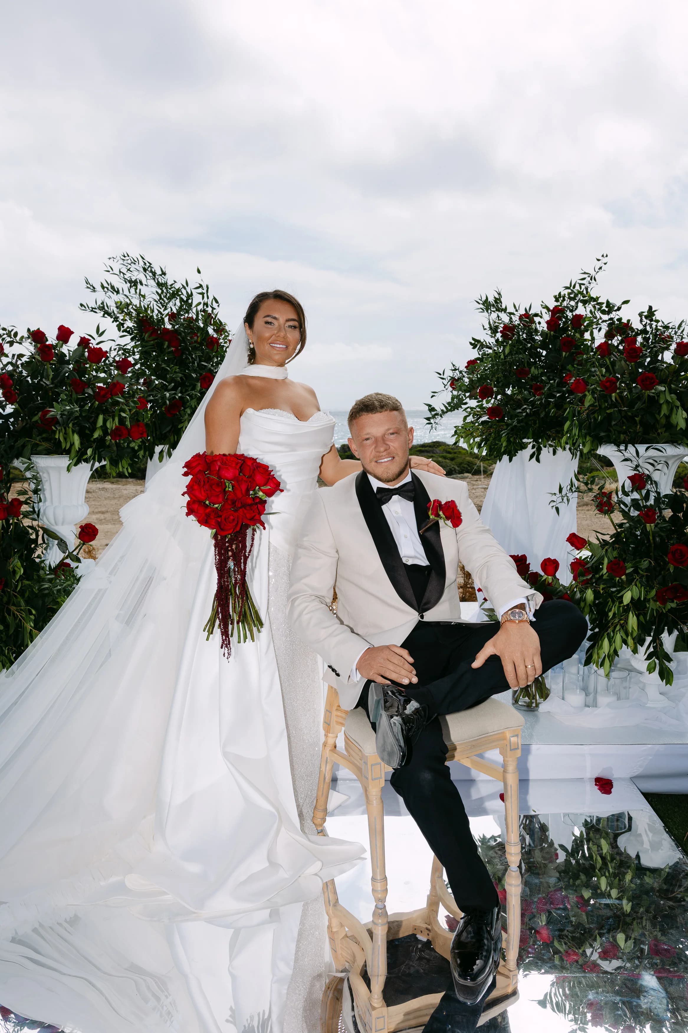 Seated couple portrait at the floral altar at Ozea after the ceremony.