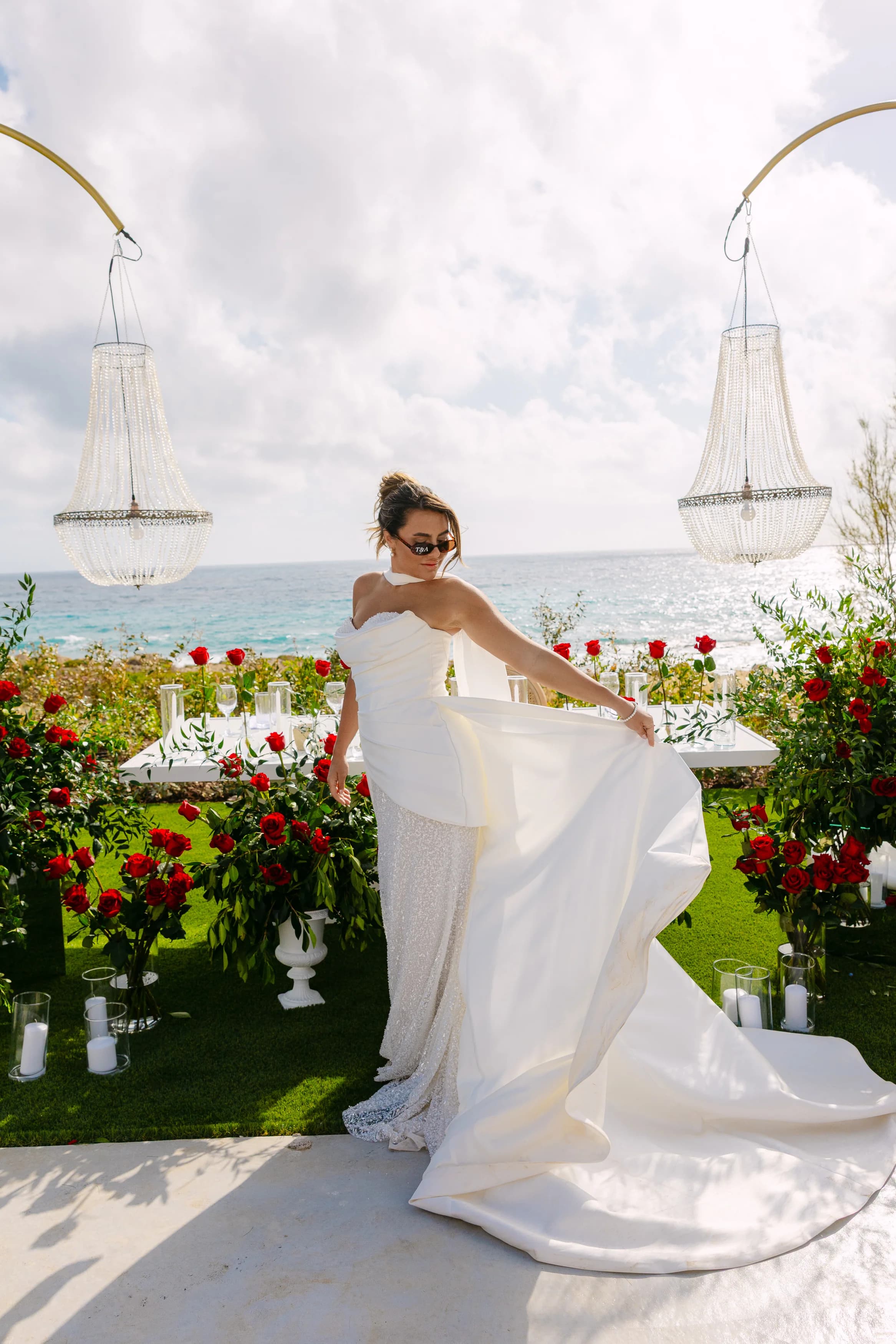 Bride twirling her dress at the head of the banquet at Ozea with chandeliers above.